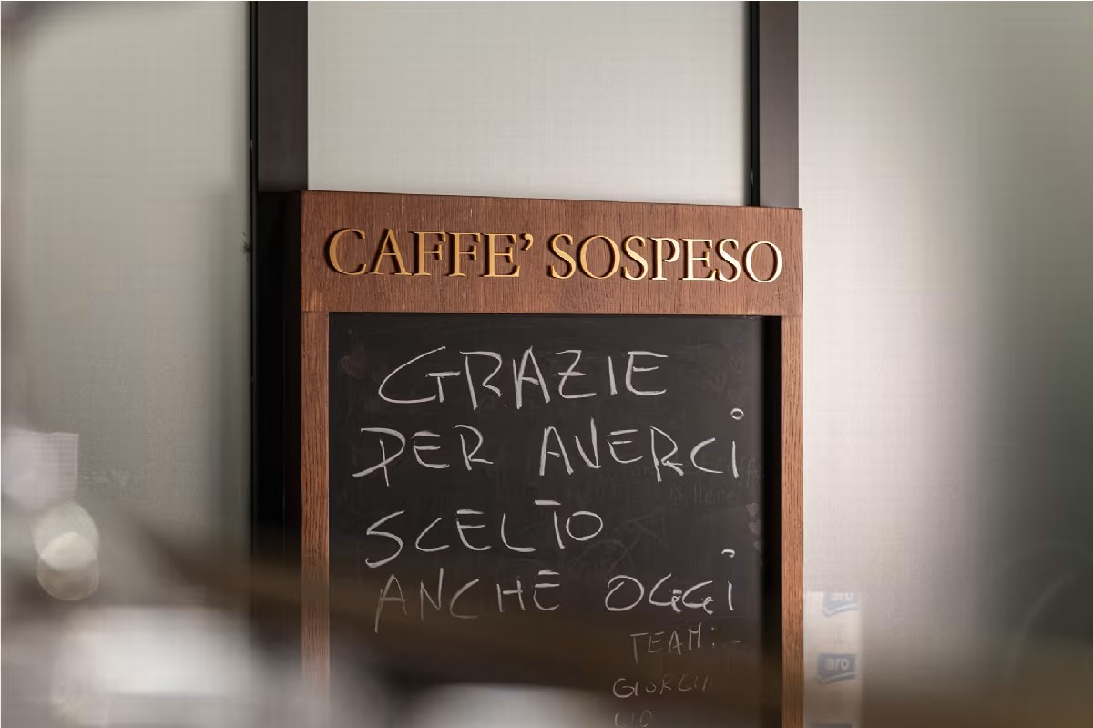 Targa del Caffè Sospeso accanto a una lavagna che ringrazia i clienti